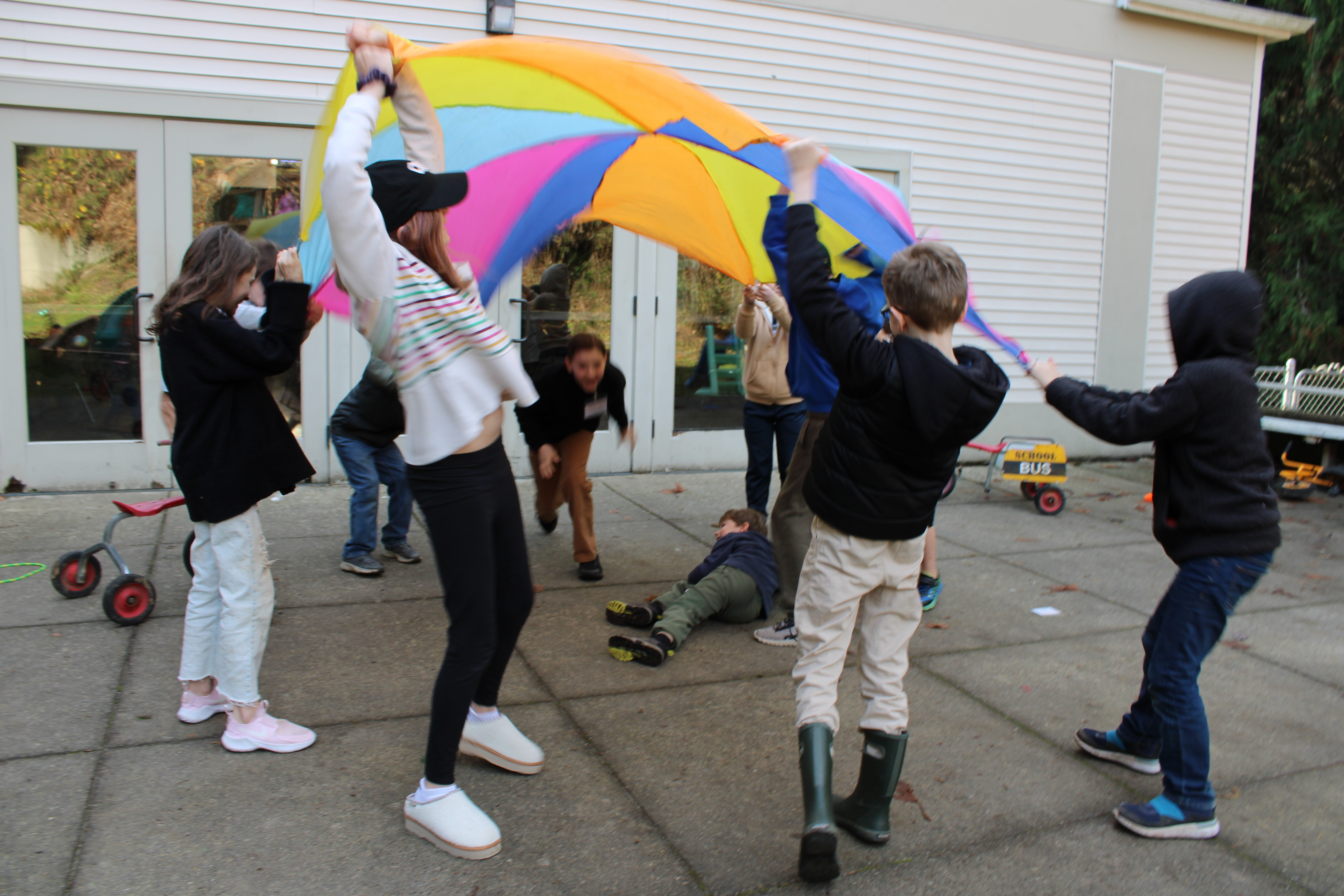NKHC children playing together with a colorful parachute